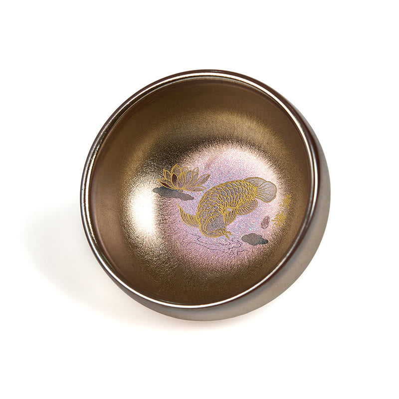 Jianzhan Koi Fish Lotus Teacup – top-down on white, bronze iridescent glaze, golden koi and lotus flower, studio product shot