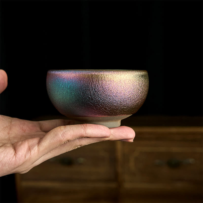 Jianzhan Koi Fish Lotus Teacup – three-quarter view, golden koi and lotus interior, metallic luster glaze, dark wood surface