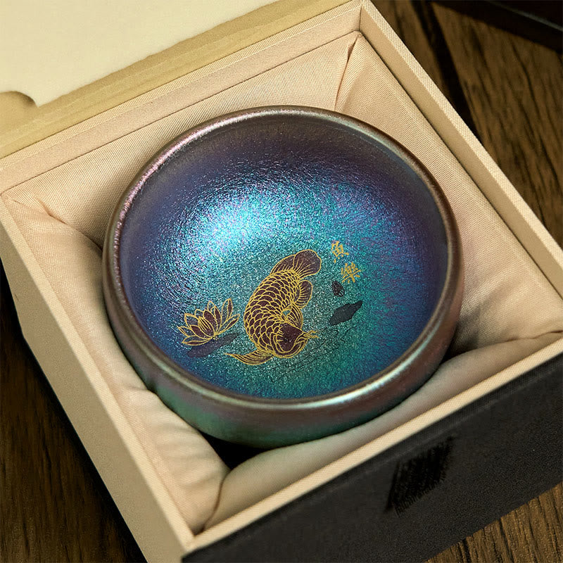 Jianzhan Koi Fish Lotus Teacup – top-down flat lay, iridescent glaze with gold koi fish, lotus and calligraphy, white bg