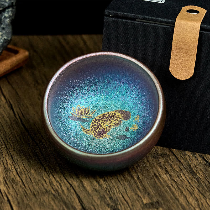 Jianzhan Koi Fish Lotus Teacup – angled overhead showing depth, iridescent metallic glaze, gold koi design, studio shot