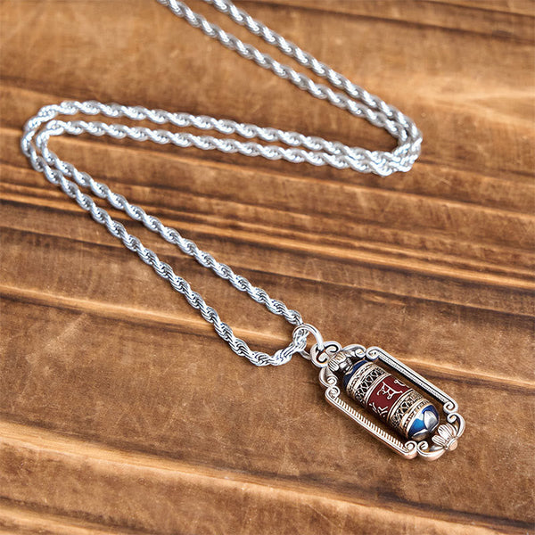 Om Mani Padme Hum Prayer Wheel Pendant – Hand-held close-up displaying multi-colored rotating barrel and ornate silver scr...