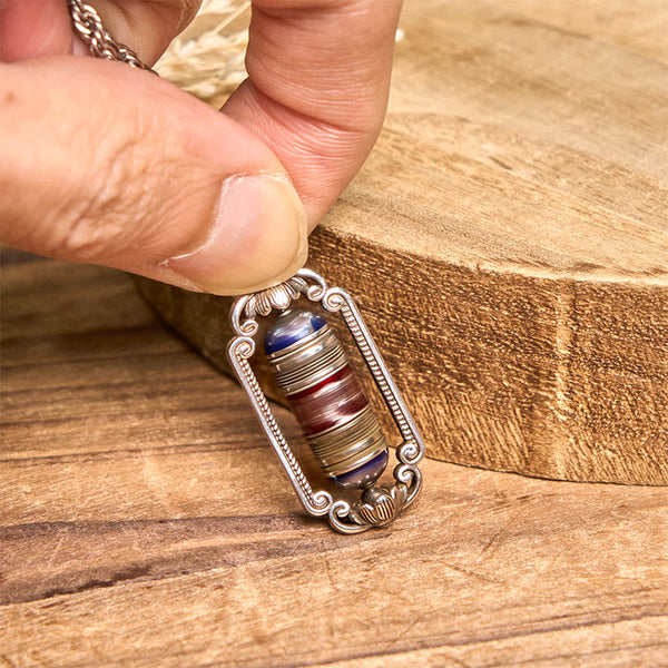 Om Mani Padme Hum Prayer Wheel Pendant – Hand-held showing pendant scale, lotus motifs and Tibetan mantra on red central band