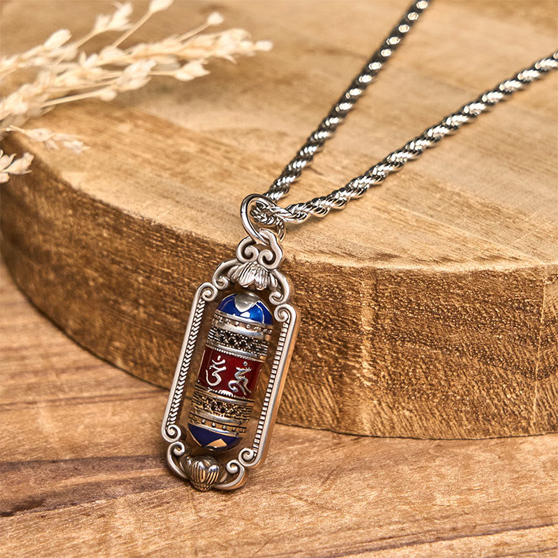 Om Mani Padme Hum Prayer Wheel Pendant – Detailed view of Om and Hrih symbols on burgundy band with faceted blue gemstone ...
