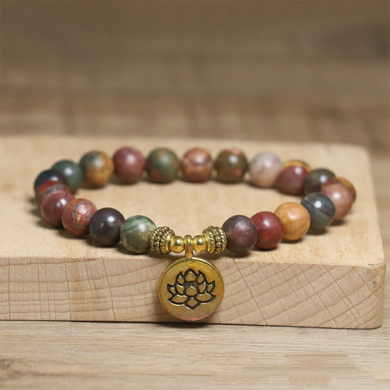 Emperor stone beaded bracelet with gold lotus charm on wood display