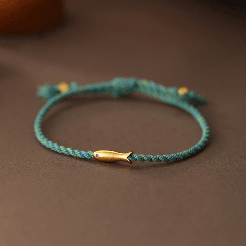 Copper Lucky Koi Fish Rope Bracelet – teal braided cord with gold koi charm on wood, luck jewelry