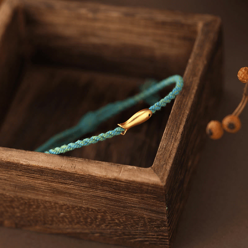 Copper Lucky Koi Fish Rope Bracelet – macro teal cord with koi charm on dark wood, feng shui