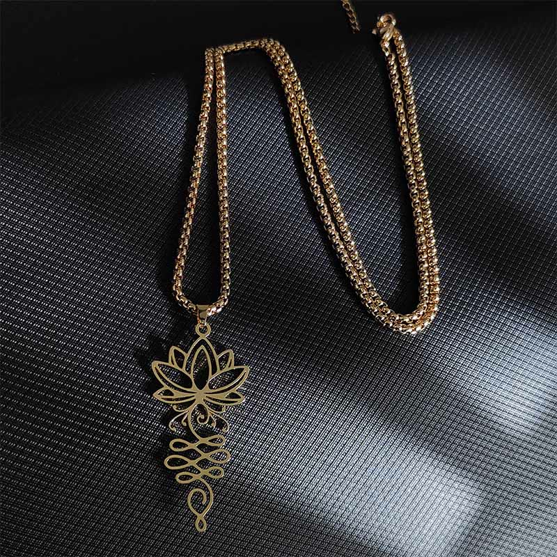 Lotus Vines Chakra Necklace – Gold lotus vine pendant in flat lay on dark backdrop, spiritual jewelry