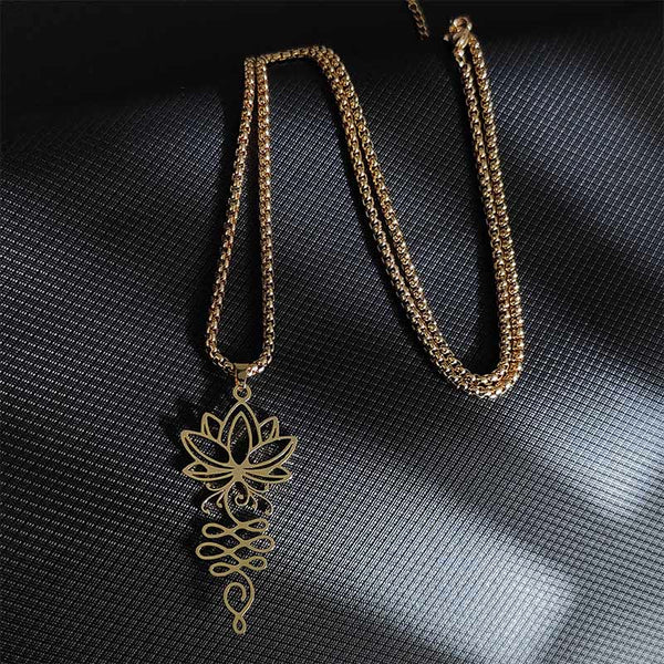 Lotus Vines Chakra Necklace – Gold lotus vine pendant in flat lay on dark backdrop, spiritual jewelry
