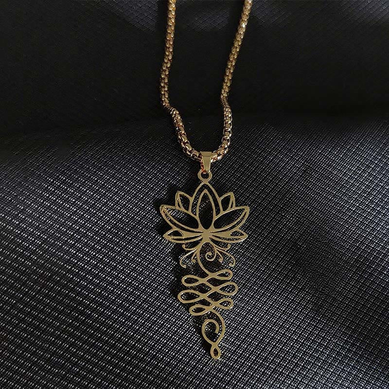 Lotus Vines Chakra Necklace – Gold lotus-unalome pendant on dark textured fabric, gold chakra necklace