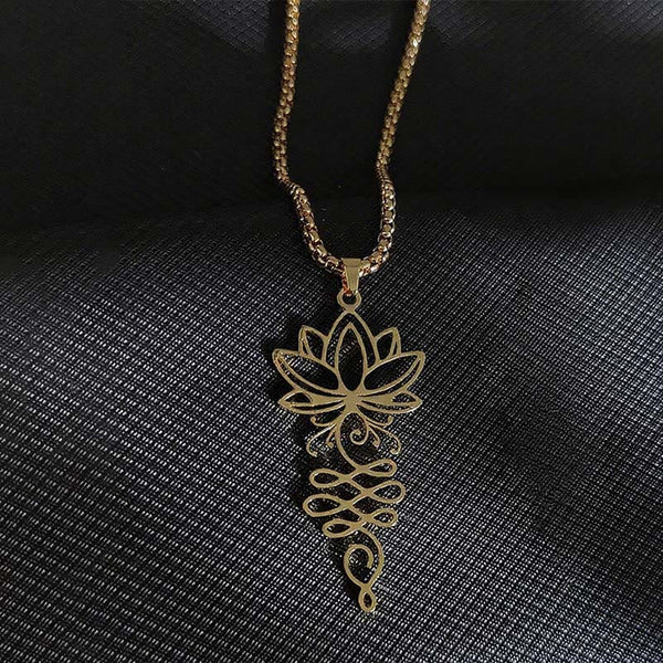 Lotus Vines Chakra Necklace – Gold lotus-unalome pendant on dark textured fabric, gold chakra necklace