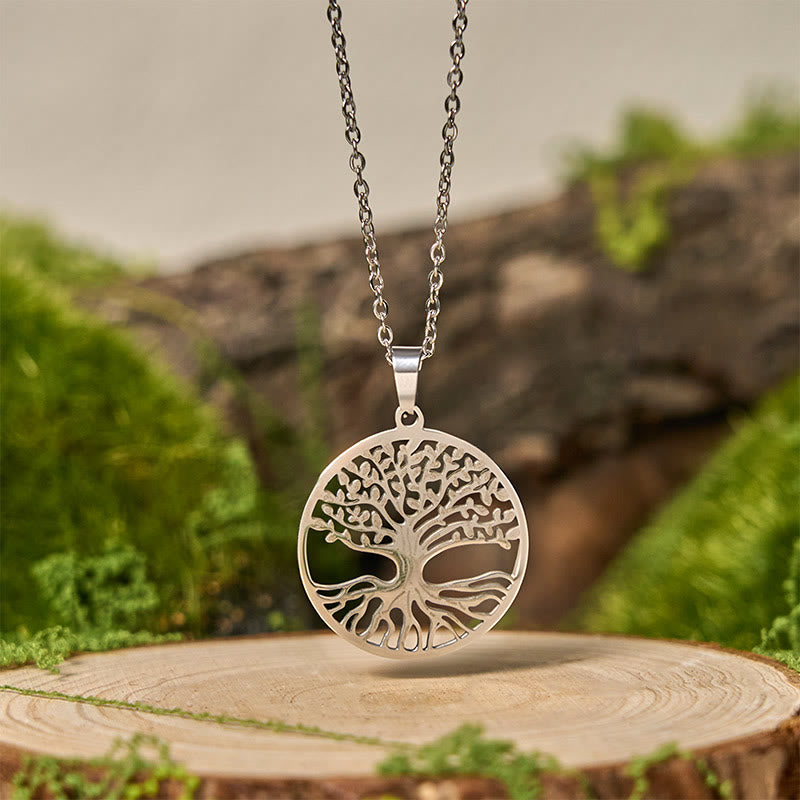Tree of Life Titanium Steel Necklace – silver pendant suspended over wood stump with moss, frontal shot