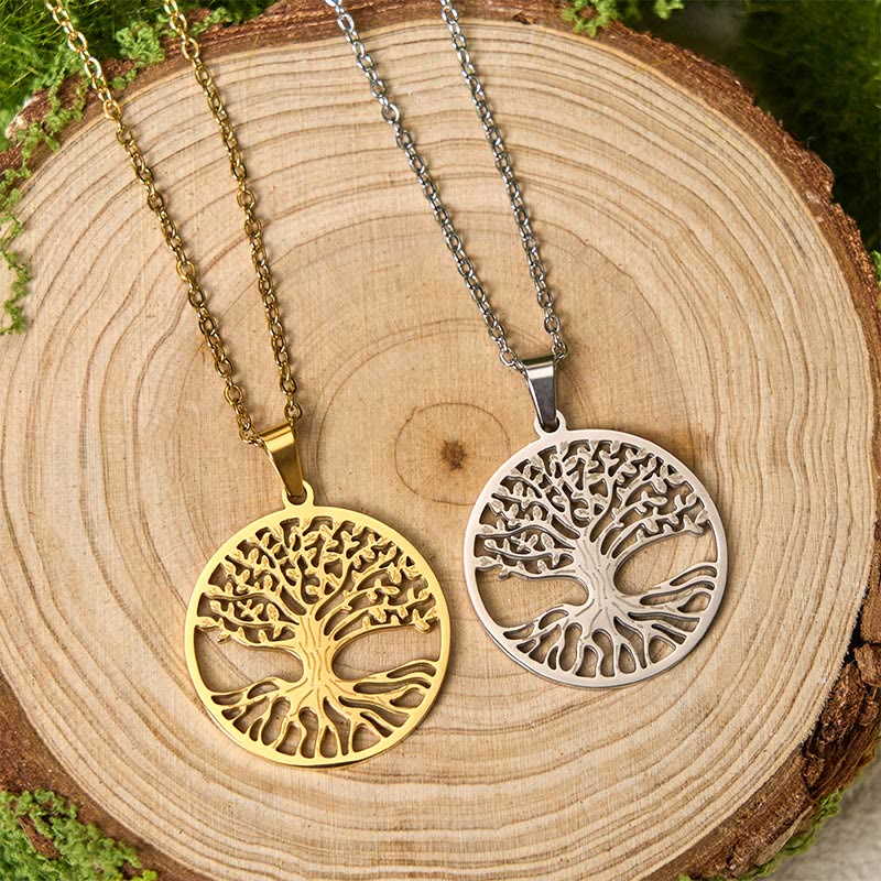 Tree of Life Titanium Steel Necklace – gold and silver pendants on tree cross-section, overhead flat lay