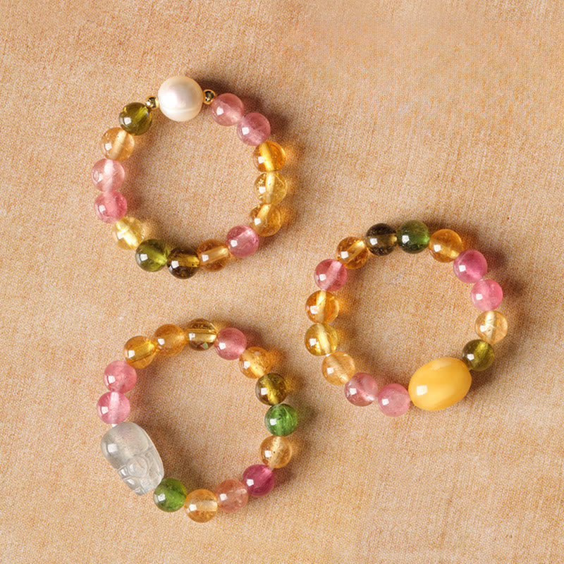 Tourmaline Pearl Amber Pixiu Ring – three styles displayed beige fabric, tourmaline pearl amber collection
