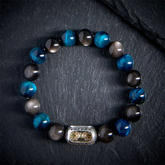Silver Obsidian Blue Tiger Eye Bracelet - top-down on dark stone, alternating blue black beads with gold pixiu charm, mens energy bracelet