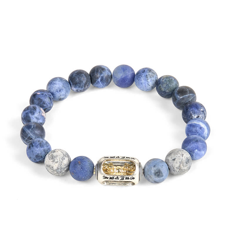 Sodalite Grey Jasper Om Bracelet – flat lay on white, full blue bead strand with silver mantra bead, sodalite jewelry