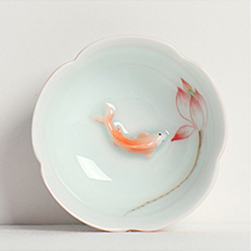 Koi Fish & Lotus Tea Cup – Top-down view of swimming koi and lotus bud in celadon, porcelain cup
