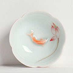 Koi Fish & Lotus Tea Cup – Top-down view of swimming koi and lotus bud in celadon, porcelain cup