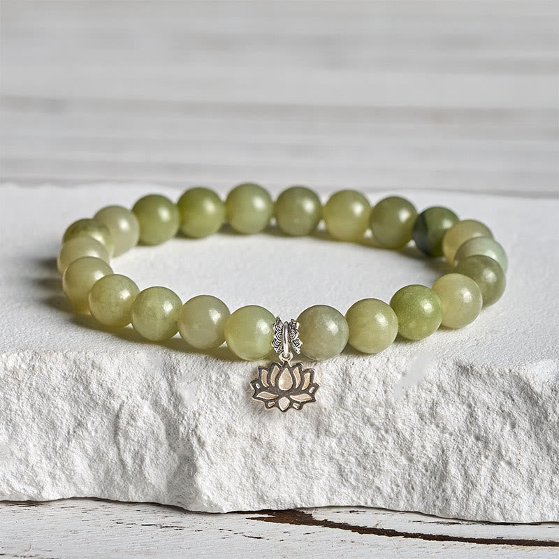Cyan Jade Lotus Bracelet on white stone pedestal, natural stone bead bracelet