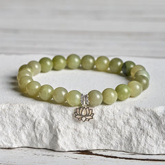 Cyan Jade Lotus Bracelet on white stone pedestal, natural stone bead bracelet