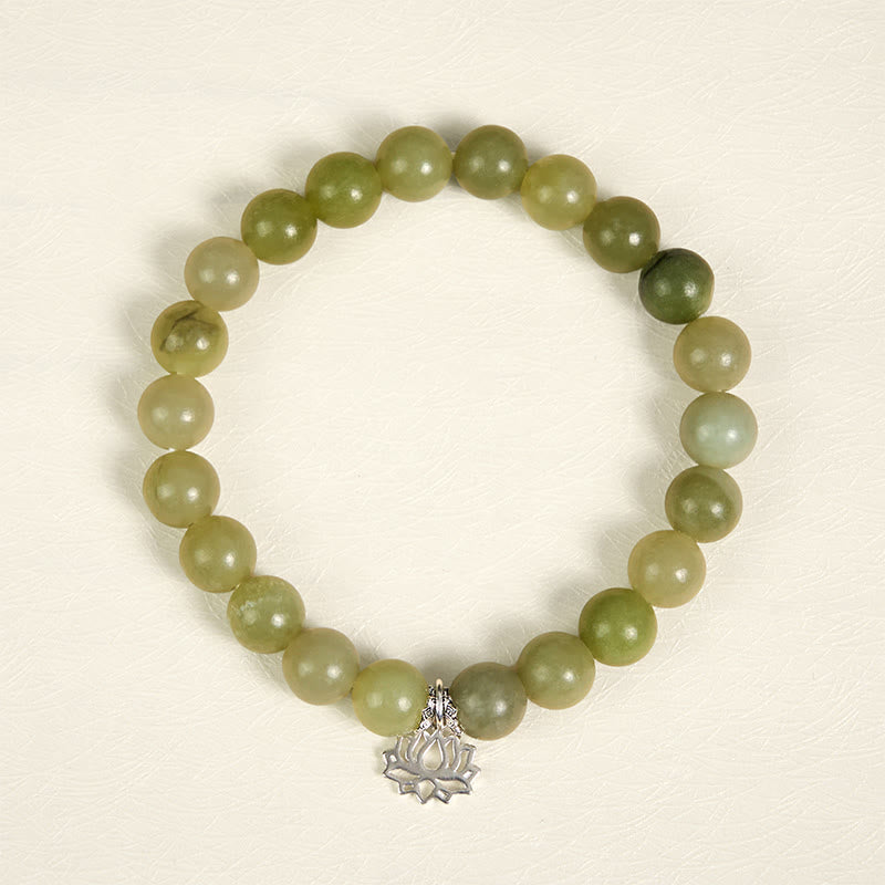 Natural Cyan Jade Bracelet flat lay with silver lotus pendant, healing gemstone