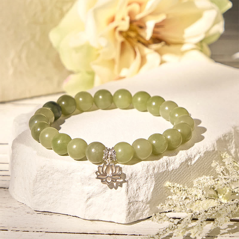 Green Jade Lotus Charm Bracelet with floral backdrop, jade bead stretch bracelet