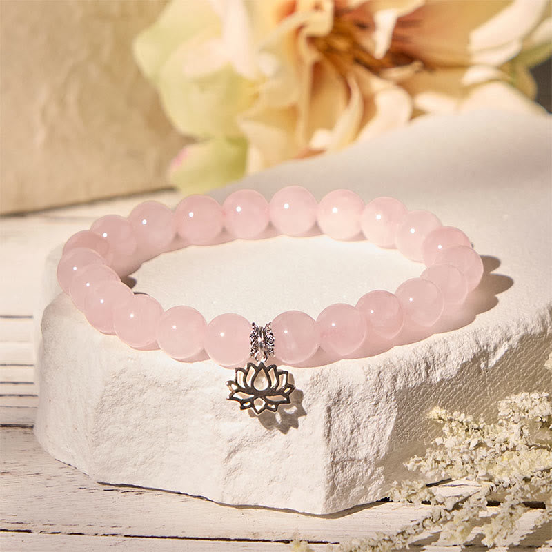 Rose Quartz Lotus Bracelet with soft floral background, pink crystal charm jewelry