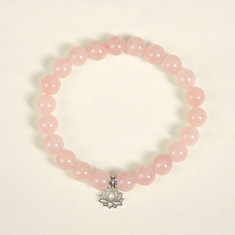 Pink Crystal Bracelet flat lay with silver lotus charm, natural rose quartz beads