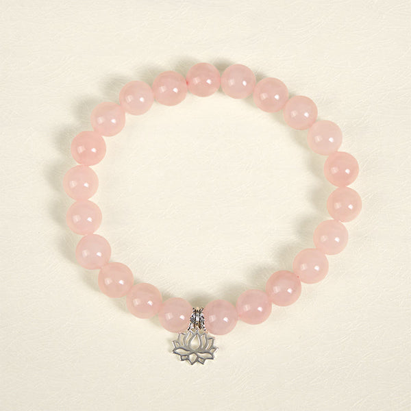 Pink Crystal Bracelet flat lay with silver lotus charm, natural rose quartz beads