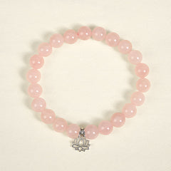 Pink Crystal Bracelet flat lay with silver lotus charm, natural rose quartz beads