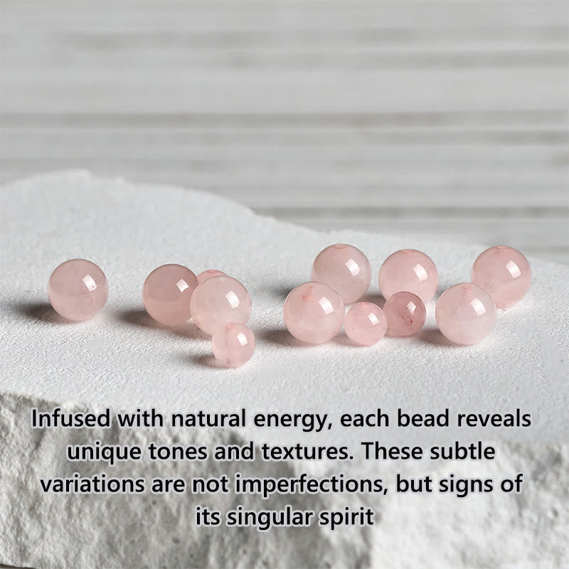 Loose Rose Quartz Beads on white stone slab, natural pink gemstone crystals
