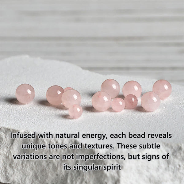 Loose Rose Quartz Beads on white stone slab, natural pink gemstone crystals