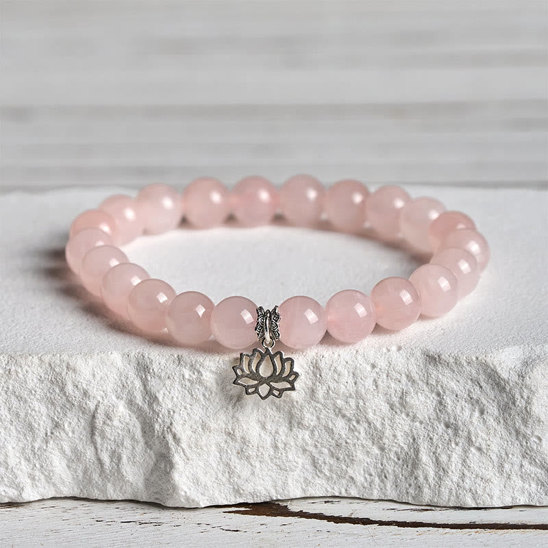 Pink Crystal Lotus Bracelet on white stone pedestal, rose quartz bead bracelet