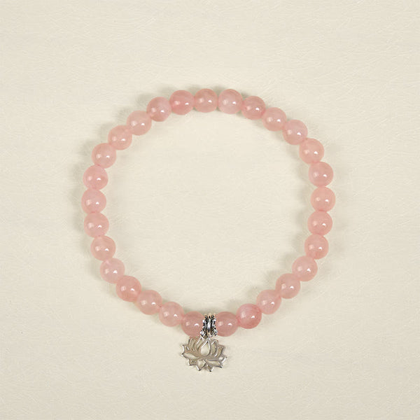 Natural Pink Crystal Bracelet overhead view with dangling lotus silver pendant