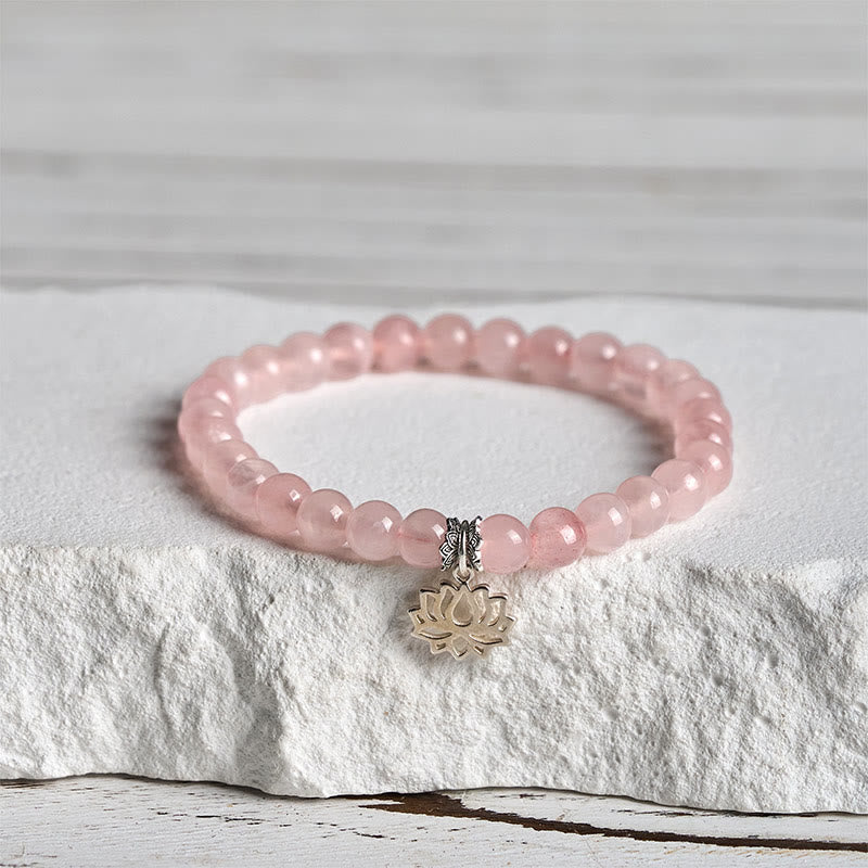 Pink Lotus Bracelet close-up on textured pedestal, silver charm rose quartz