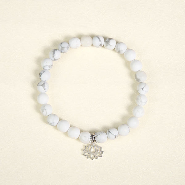 White Turquoise Lotus Bracelet – overhead flat lay, circular bead arrangement, silver lotus charm, turquoise bracelet
