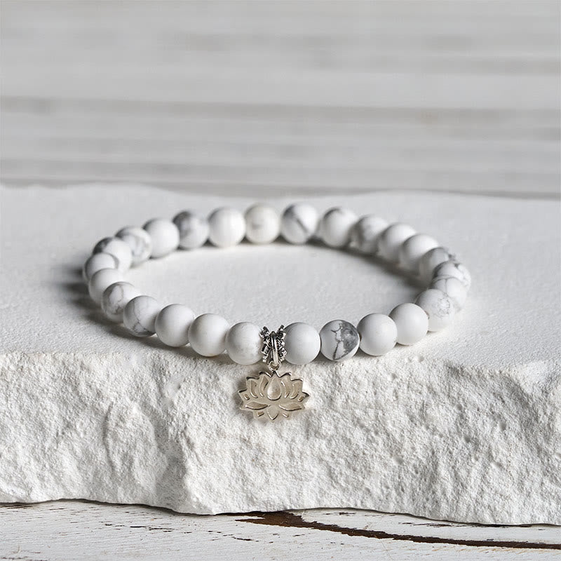 White Turquoise Lotus Bracelet – three-quarter view on stone, silver lotus charm at front, white turquoise bracelet