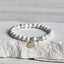 White Turquoise Lotus Bracelet – three-quarter view on stone, silver lotus charm at front, white turquoise bracelet