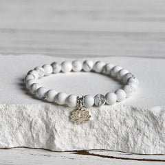 White Turquoise Lotus Bracelet – three-quarter view on stone, silver lotus charm at front, white turquoise bracelet