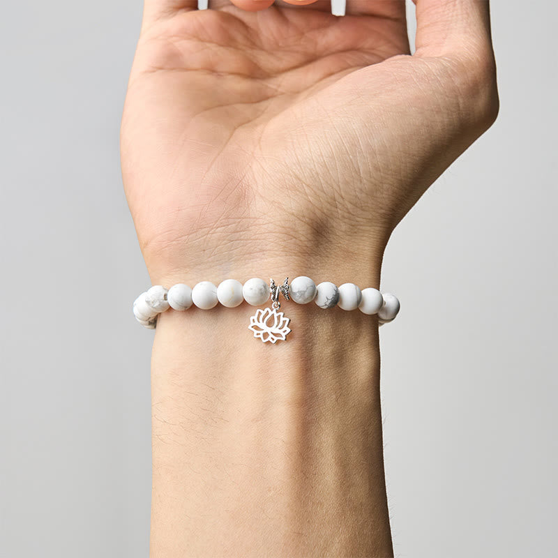White Turquoise Lotus Bracelet – worn on wrist, palm-up view showing silver lotus charm, white turquoise stretch bracelet
