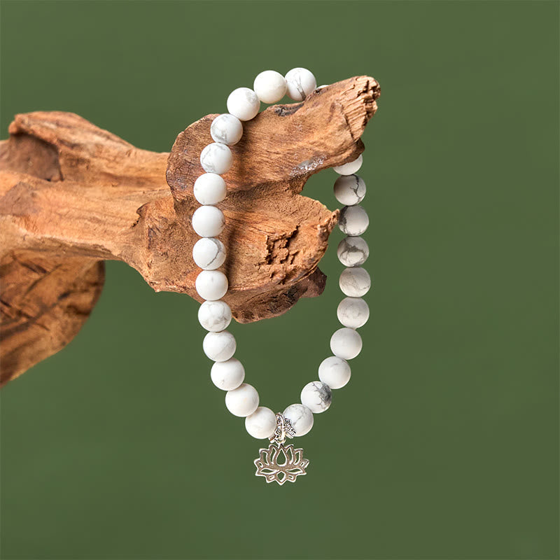 White Turquoise Lotus Bracelet – draped on driftwood against sage green, silver lotus pendant, white turquoise beads
