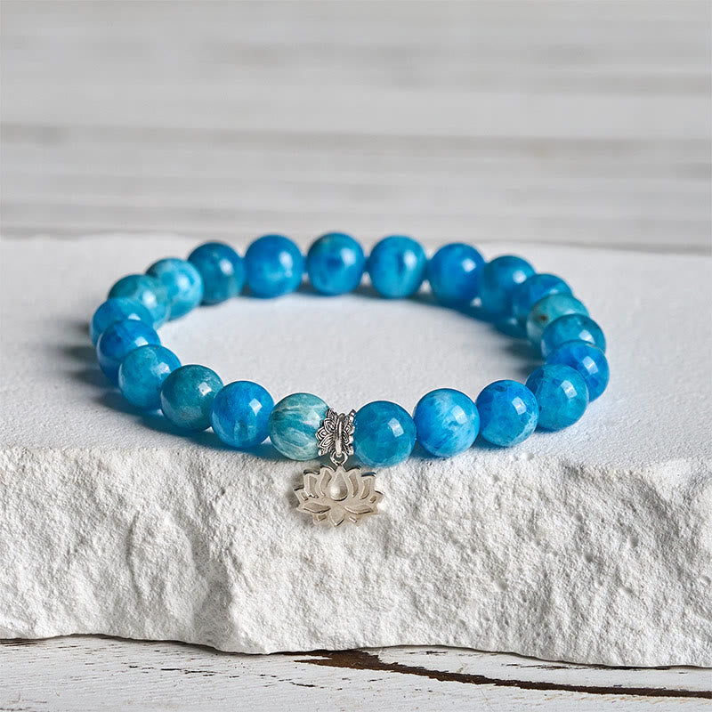 Apatite Lotus Silver Bracelet – three-quarter view on stone, silver lotus charm with blue apatite beads, gemstone bracelet