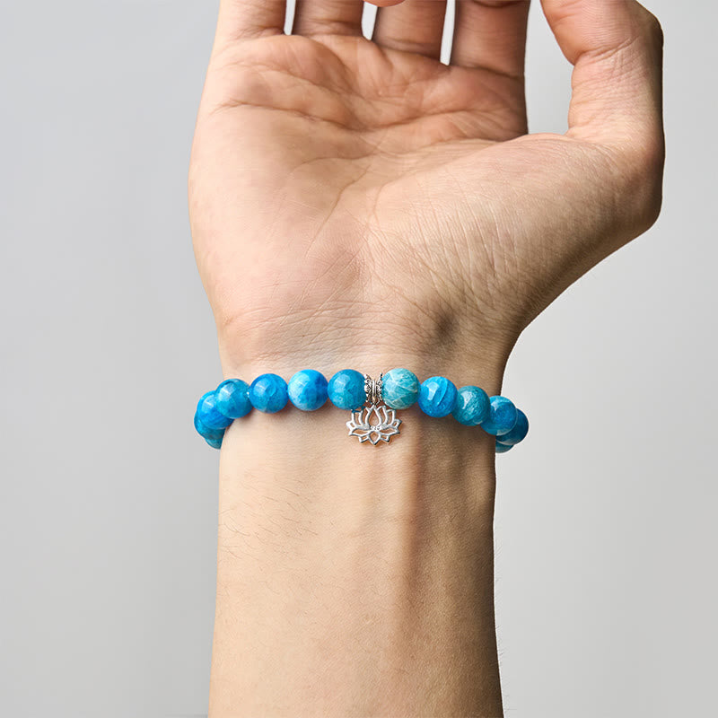 Apatite Lotus Silver Bracelet – worn on wrist, palm-up view, silver lotus charm with blue apatite stretch bracelet