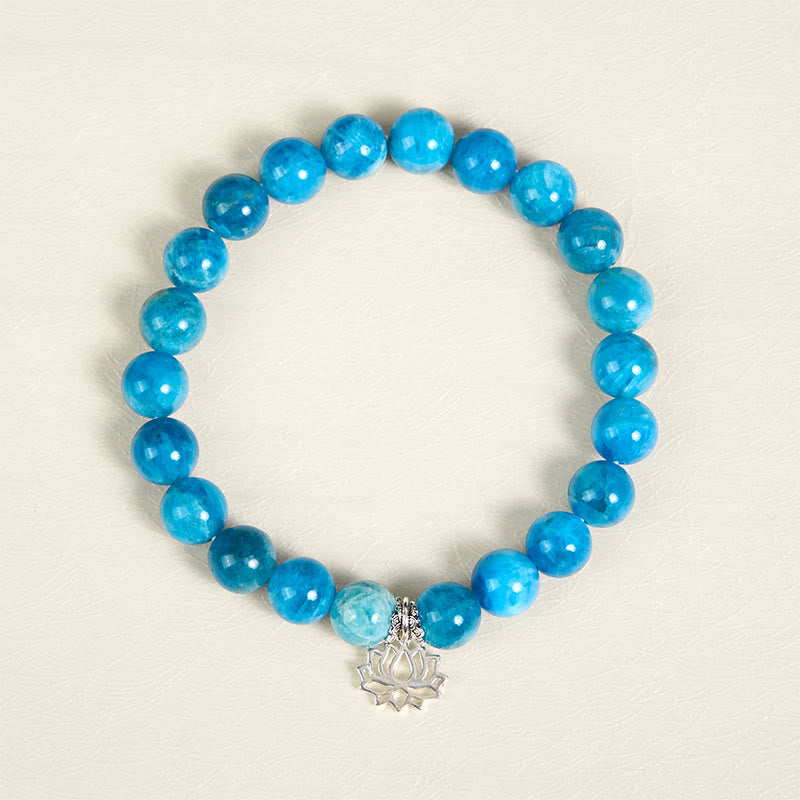 Apatite Lotus Silver Bracelet – overhead flat lay, vibrant blue apatite beads, silver lotus charm, cyan stone bracelet