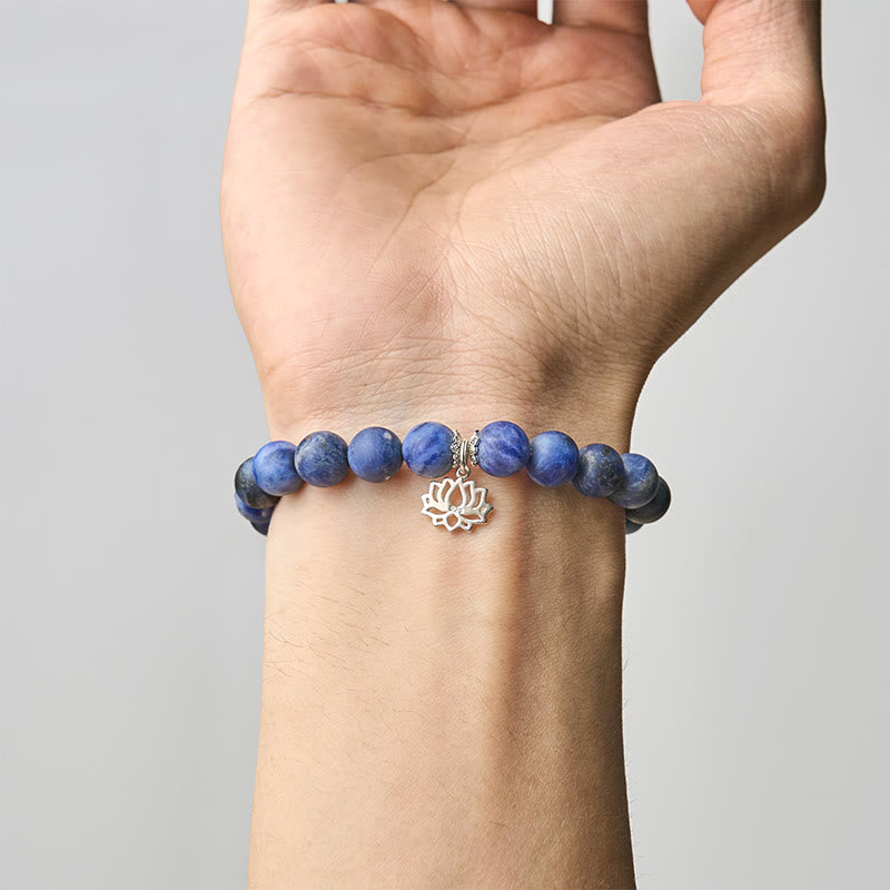 Sodalite Lotus Bracelet – worn on wrist showing blue beads and silver lotus pendant, crystal bracelet
