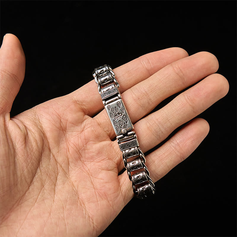 Copper Auspicious Clouds Om Mani Padme Hum Bracelet – Curved view on textured surface, oxidized copper chain bracelet