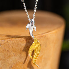 Silver Golden Koi Fish Luck Necklace – macro three-quarter view of leaping koi on polished wooden stump