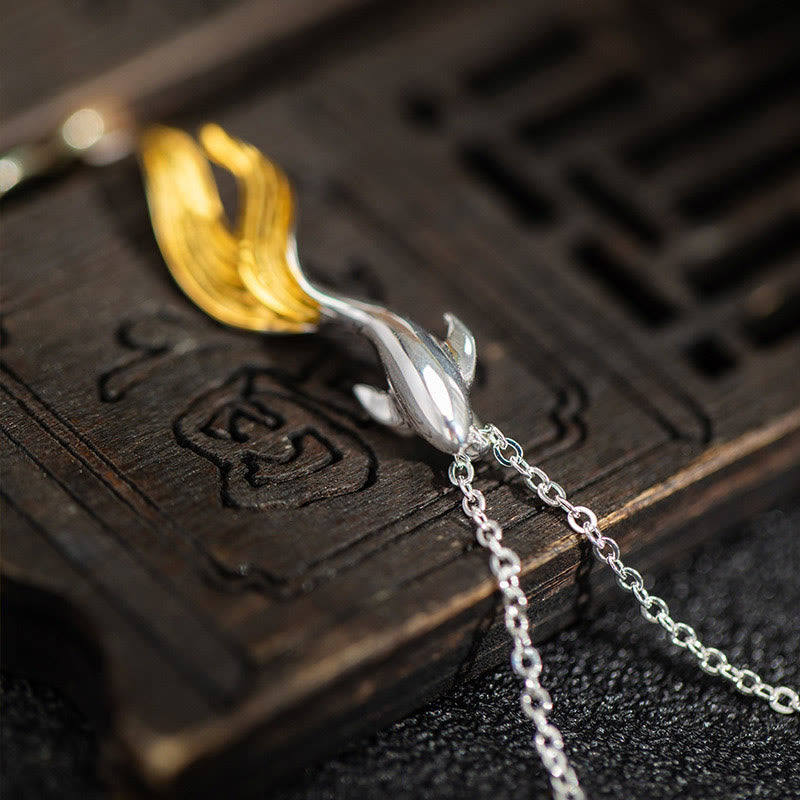 Silver Golden Koi Fish Luck Necklace – close-up koi pendant on antique carved wooden box, moody lighting