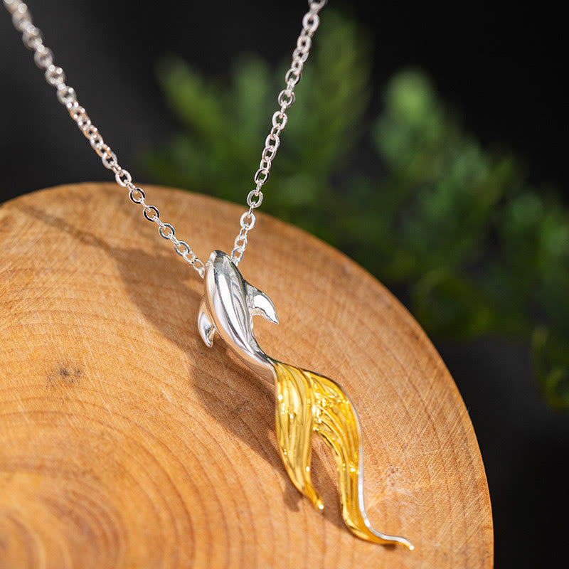 Silver Golden Koi Fish Luck Necklace – koi pendant on natural wood with green foliage blurred background