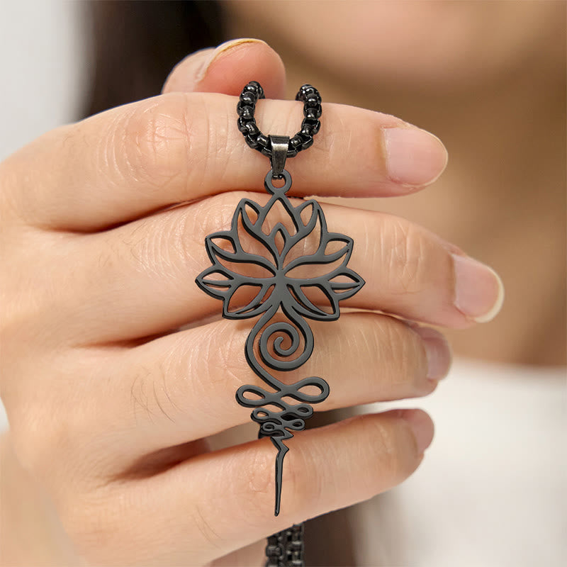 Lotus Unalome Chakra Necklace – Black lotus-unalome pendant held in fingers, mindfulness spiritual jewelry