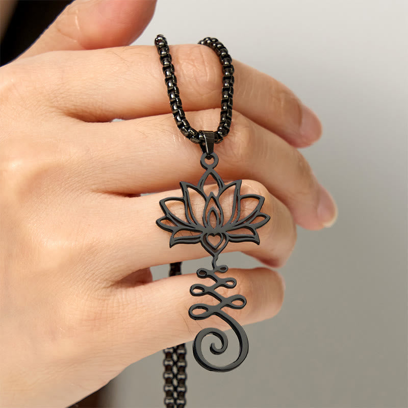 Chakra Lotus Necklace – Black lotus-unalome pendant held in hand showing detail, spiritual necklace